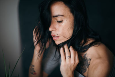 Close-up of young woman against black background