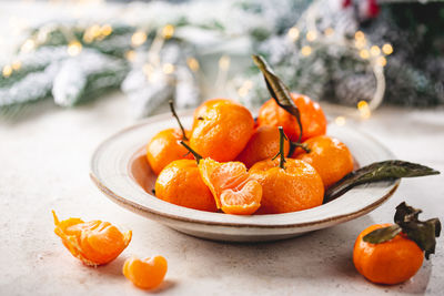 Close-up of orange fruits in plate on table