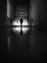 Rear view of silhouette man walking in corridor