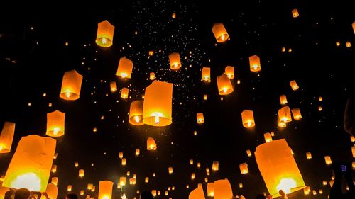 Low angle view of illuminated lanterns in city at night