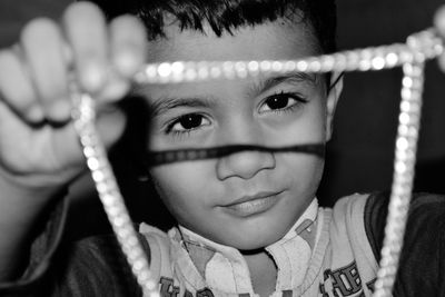 Close-up of boy holding necklace