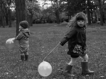 Full length of siblings playing at park