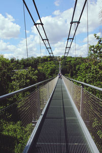 Footbridge over plants against sky