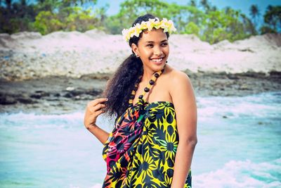 Portrait of a smiling young woman standing on beach