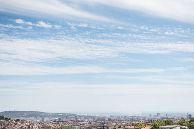 Aerial view of buildings in city against sky