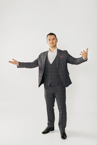 Portrait of young man standing against white background