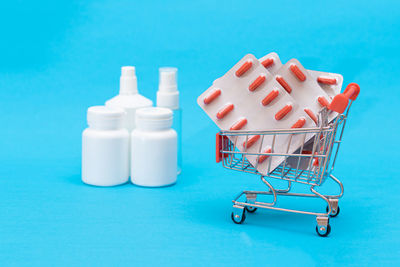 Close-up of medicines in bottles against blue background