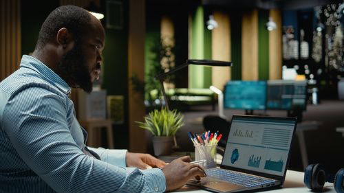 Side view of man using laptop at office
