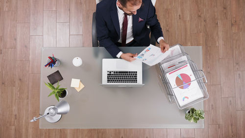 High angle view of people using laptop on table