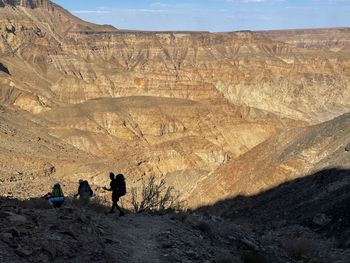 Rear view of people walking on rock formation