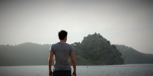 Rear view of woman standing in lake