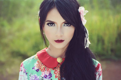 Portrait of beautiful woman standing on field