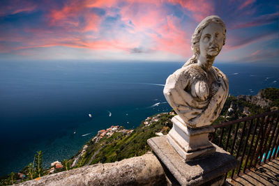 Statue by sea against sky