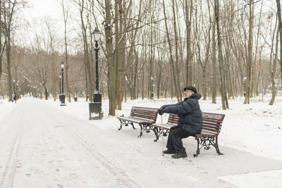 Man sitting on snow covered road