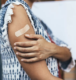 Arm of unrecognizable latin woman who just received a dose of coronavirus vaccine