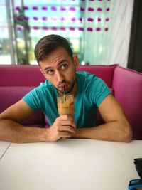 Portrait of young man sitting on table