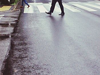 Low section of woman walking on road