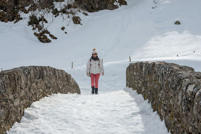 Woman standing on snow covered landscape during winter