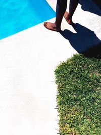 Low section of woman standing by swimming pool