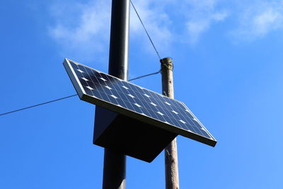 Low angle view of traditional windmill against blue sky