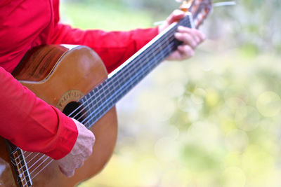 Midsection of man playing guitar