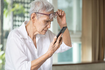 Midsection of man holding eyeglasses