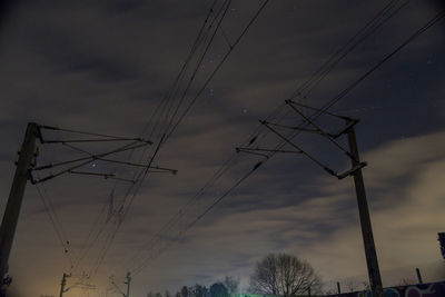 Low angle view of silhouette electricity pylon against sky