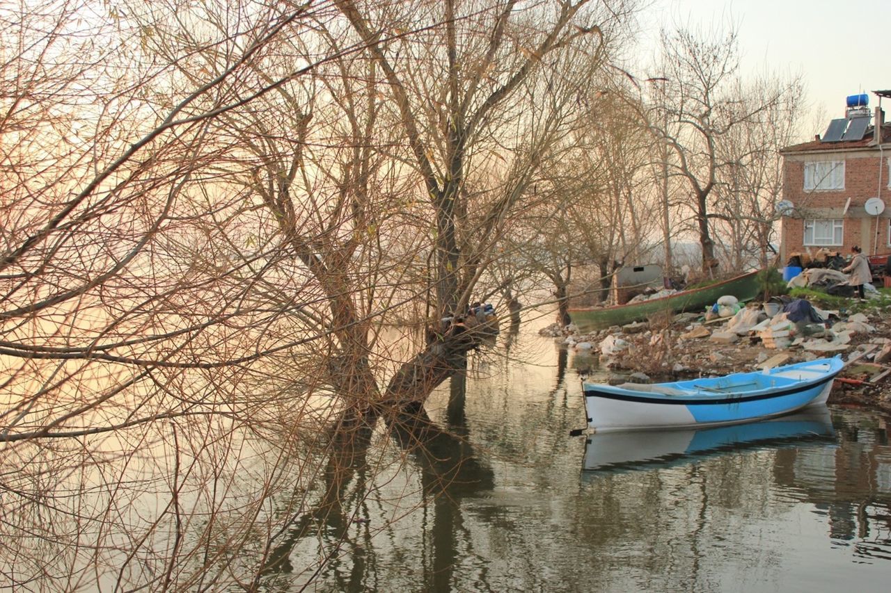 tree, water, bare tree, building exterior, built structure, architecture, branch, waterfront, nautical vessel, boat, lake, nature, moored, sky, transportation, tranquility, house, day, tranquil scene, growth