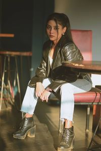 Full length of young woman sitting on chair