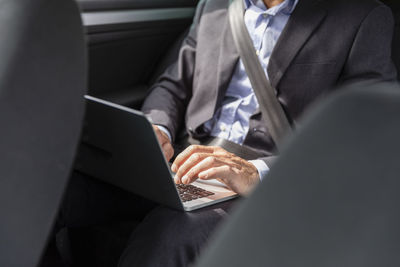 Male professional using laptop in car