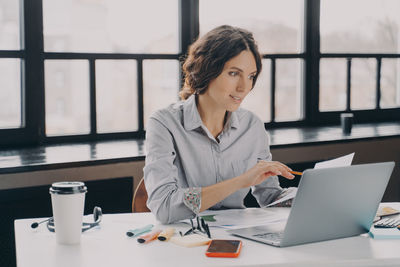 Businesswoman using laptop at office