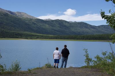 Rear view of people on lake against mountains