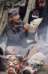 Full length of young man sitting outdoors