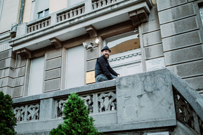 Low angle view of young man standing against building