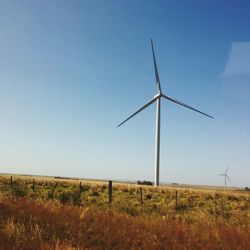 Windmill on field against clear sky