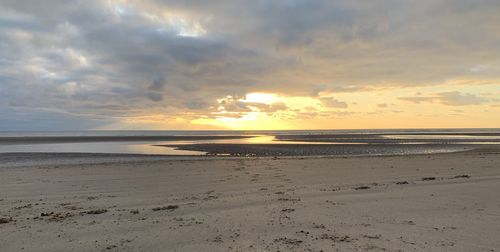 Scenic view of beach against sky during sunset