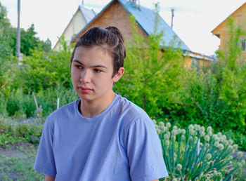 Portrait of teenage girl standing against plants