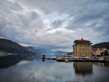 River by buildings in city against sky