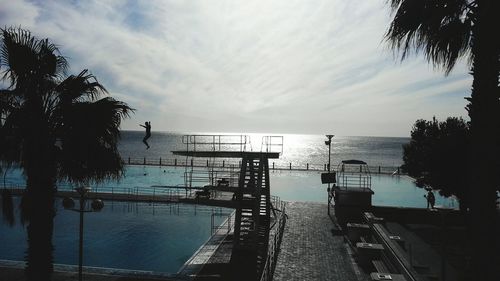 Person diving from platform in swimming pool