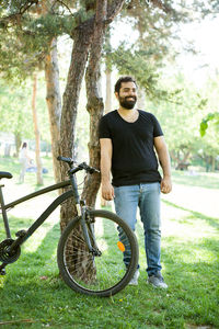 Portrait of senior man riding bicycle on field