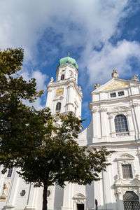 The front of st. stephen's cathedral in passau, bavaria, germany in autumn with multicolored tree 
