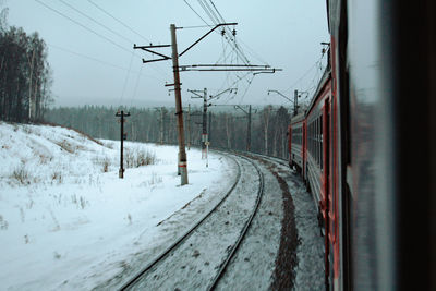 Train on railroad track against sky during winter