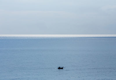 Boat sailing on sea against sky