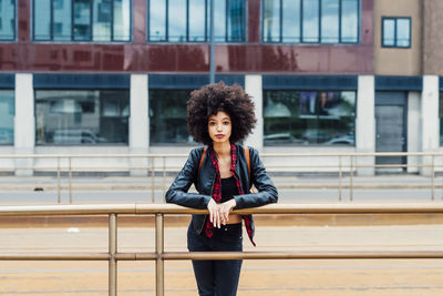 Young woman staring while leaning on railing