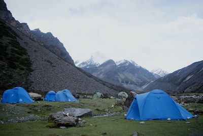 Scenic view of camping in mountains against sky