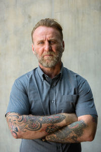 Portrait of man standing against wall