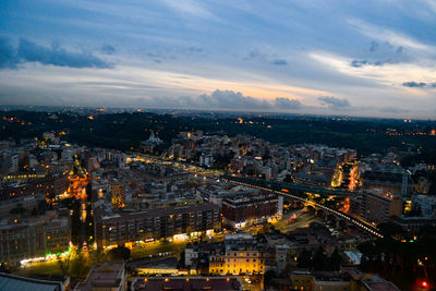 High angle view of illuminated buildings in city at sunset