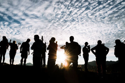 Silhouette people against sky during sunset