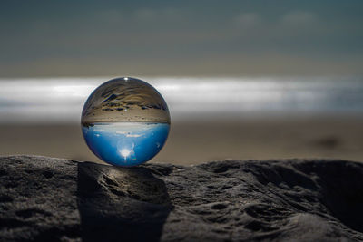 Close-up of crystal ball on beach