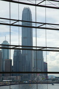 Modern buildings against sky seen through glass window